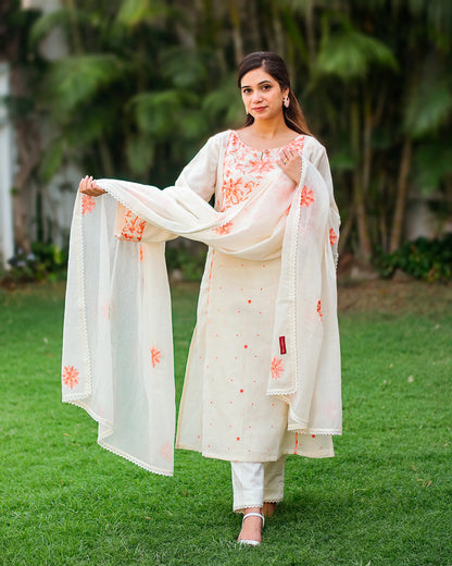 Indian woman in a summer-ready off-white kurta set with peach Kashmiri work. 