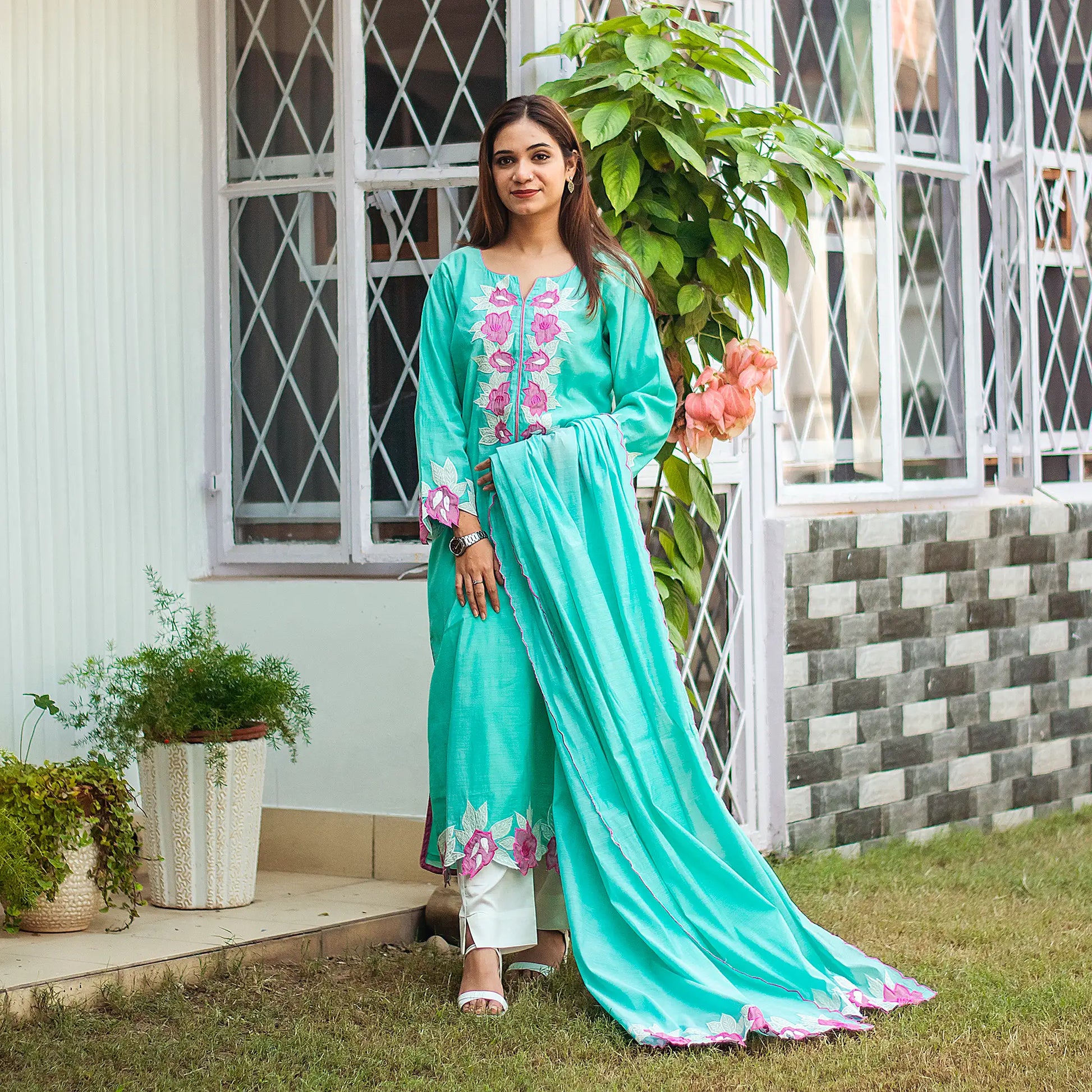 Indian woman dressed in a blue chanderi kurta and dupatta with purple floral patchwork, paired with off-white trousers.