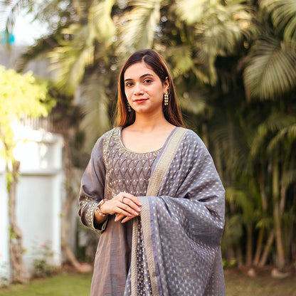 Close-up of the model focused on the intricate zardozi work on the yoke of the grey silk kurta.