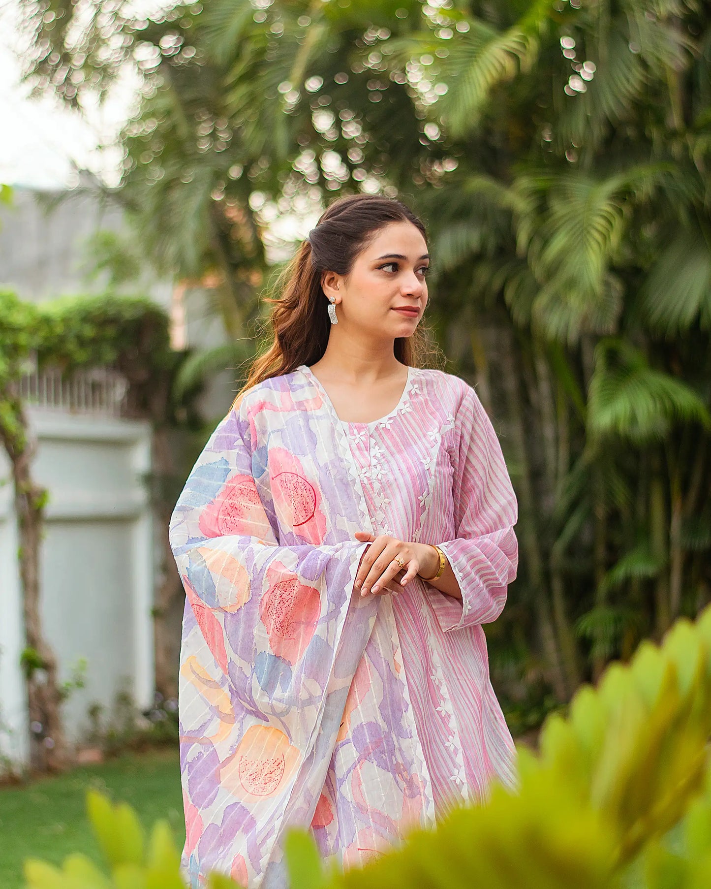 Close-up of an Indian model in a light pink kurta with applique work, paired with a pastel abstract printed dupatta.