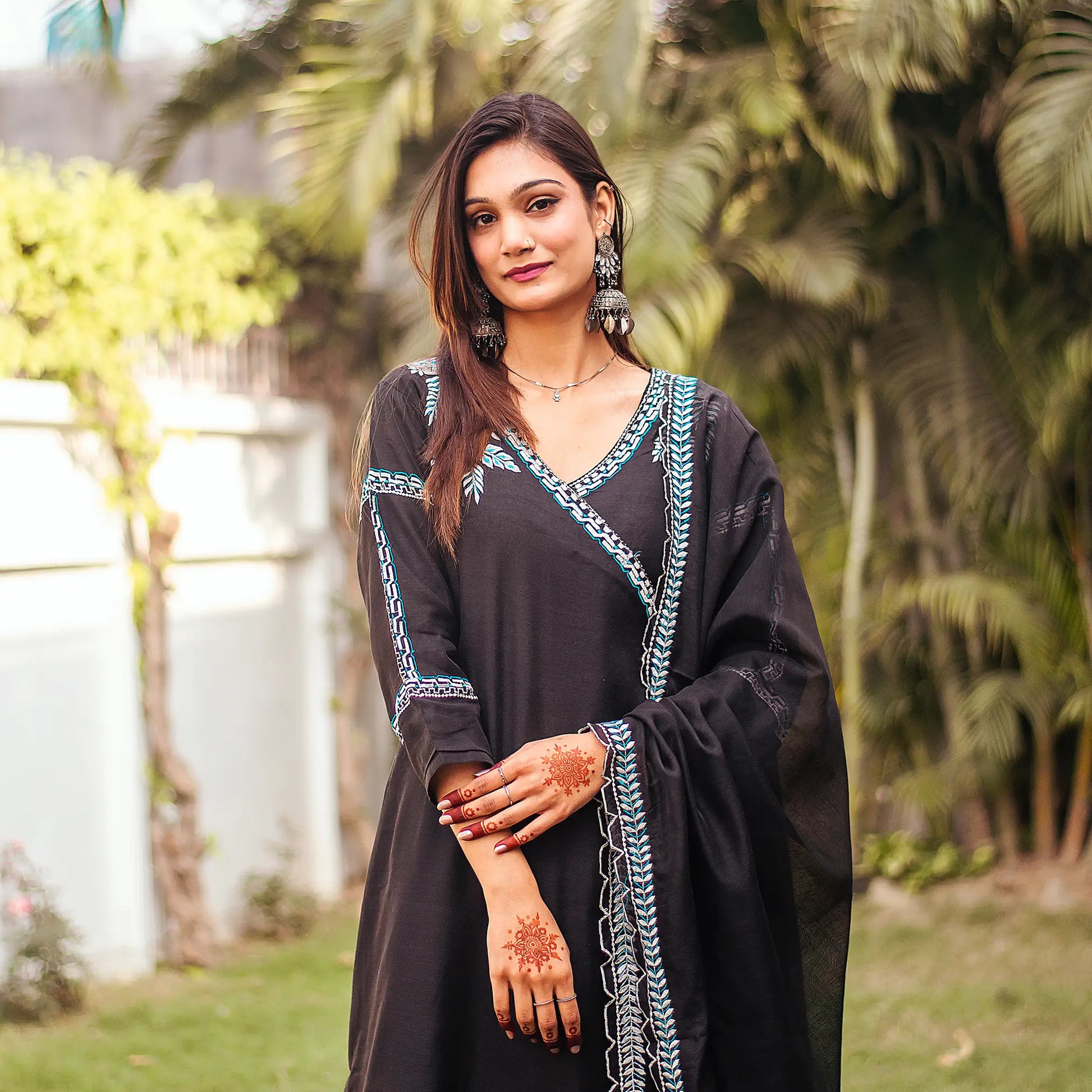 Indian model in a close-up view, highlighting the black chanderi angrakha kurta with white embroidery and dupatta.