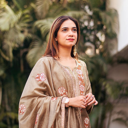 Indian model in a beige Chanderi kurta and dupatta with golden gota patti work.