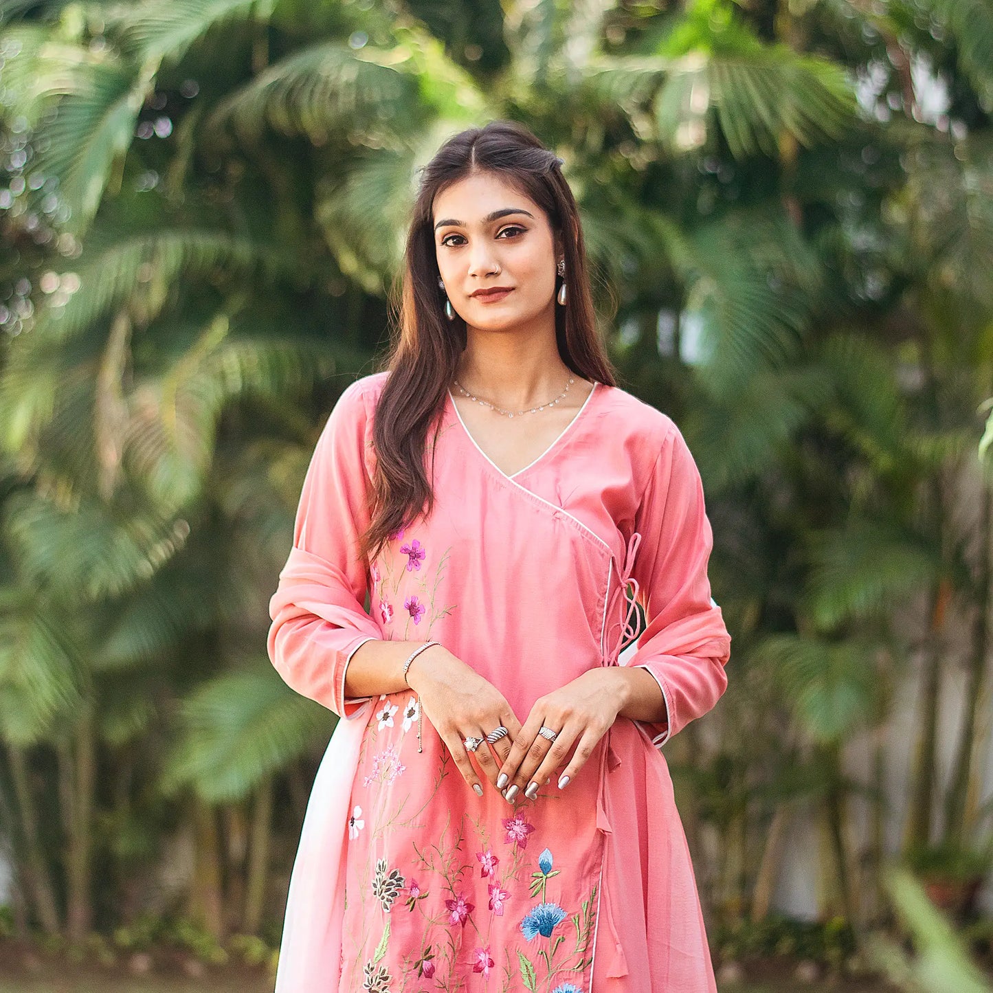 Upper front view of a model wearing the pink chanderi kurta set, featuring a pink chanderi angrakha and a pink chiffon dupatta.