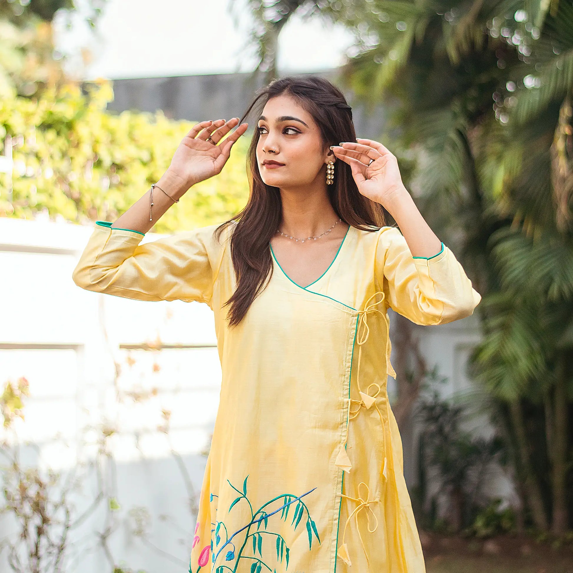 Indian model in a yellow angrakha kurta with pink and teal floral resham embroidery