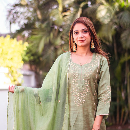 Close-up of an Indian model wearing a green jute silk kurta with beige applique work, holding the matching green chanderi dupatta.