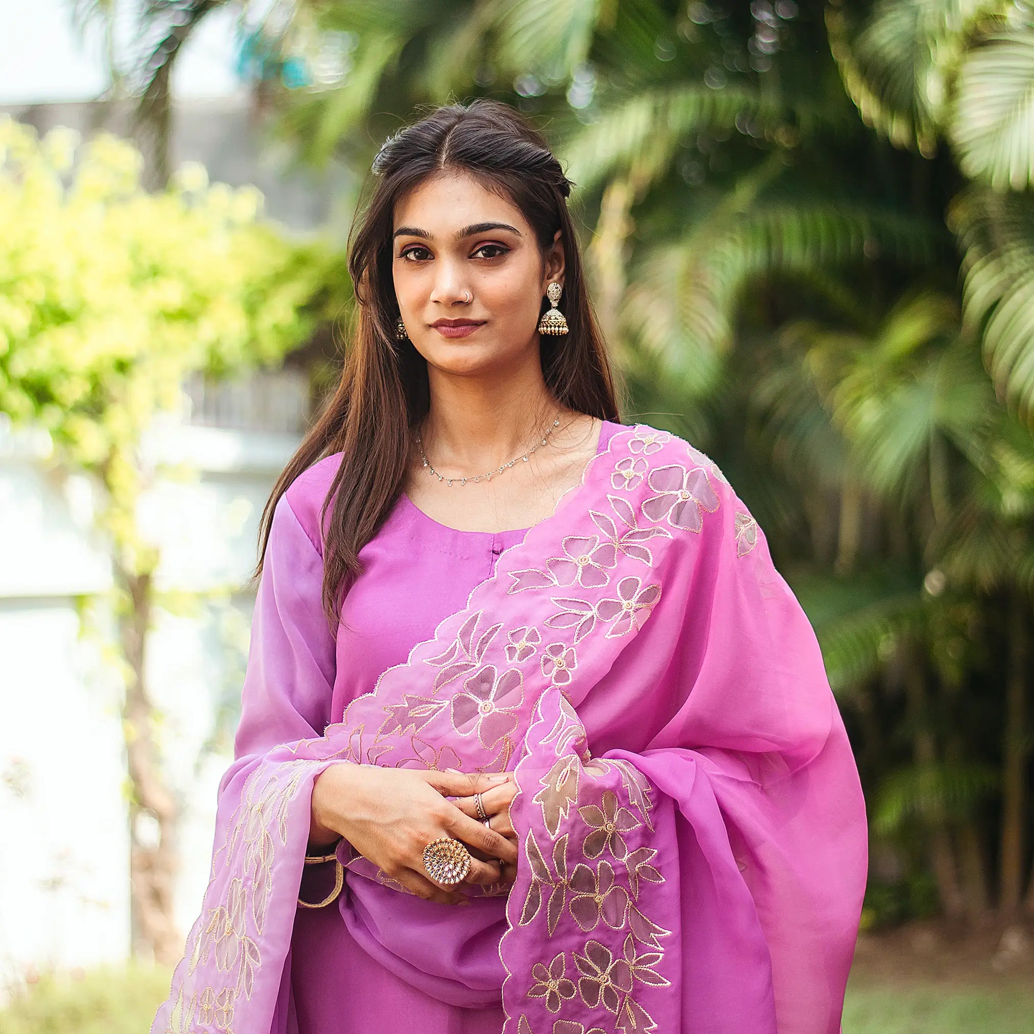 Close-up of an Indian model wearing a light purple organza kurta with golden floral cutwork, paired with a matching cutwork dupatta.