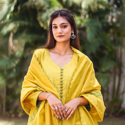 Upper front view of a model wearing the cutwork kurta set, featuring a yellowish-green chanderi kurta with green floral cutwork, matching trousers, and a green chanderi cutwork dupatta.