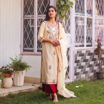 Indian woman posed in a beige chanderi kurta and dupatta with maroon applique work and a maroon palazzo.