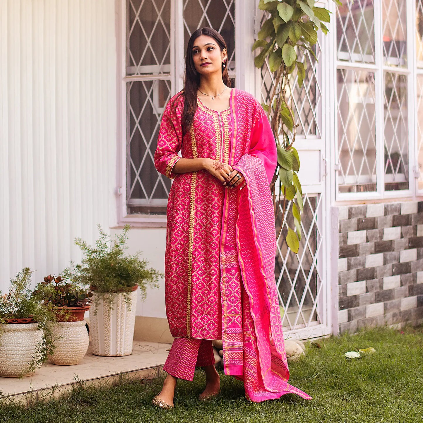 ndian lady poses in a magenta chanderi kurta adorned with beige applique motifs, paired with a magenta dupatta and trousers.