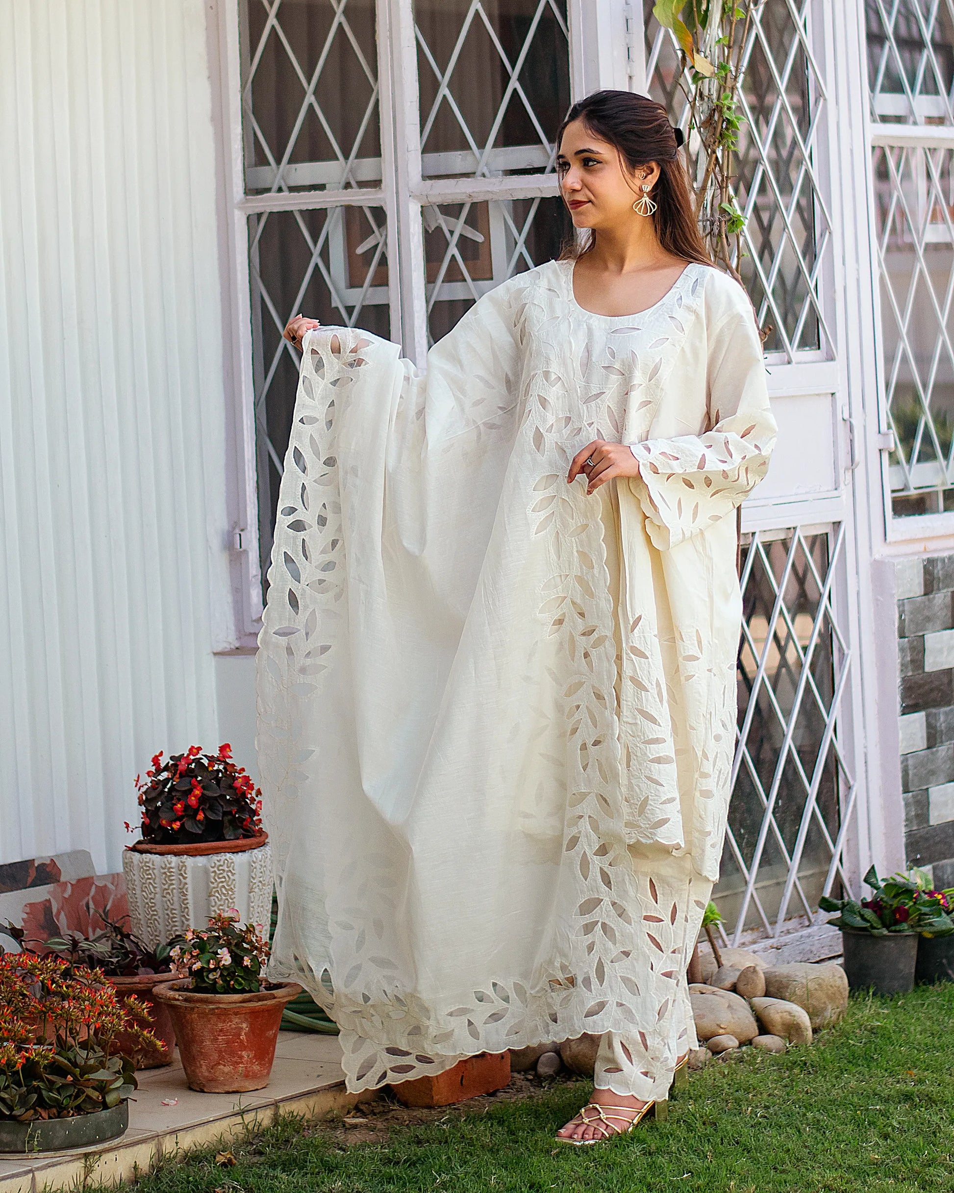 Indian model in an off-white cotton kurta set with floral cutwork embroidery. 