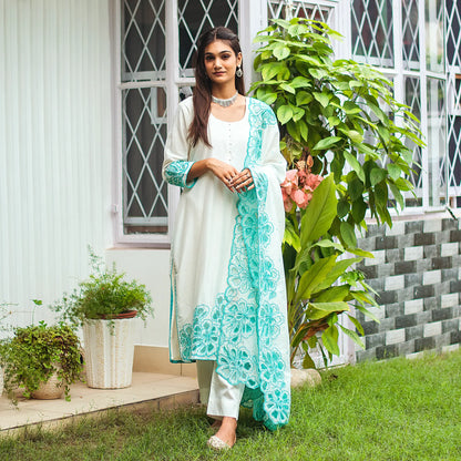 Model wearing the off-white Chanderi suit with cyan green floral cutwork, posing a little differently