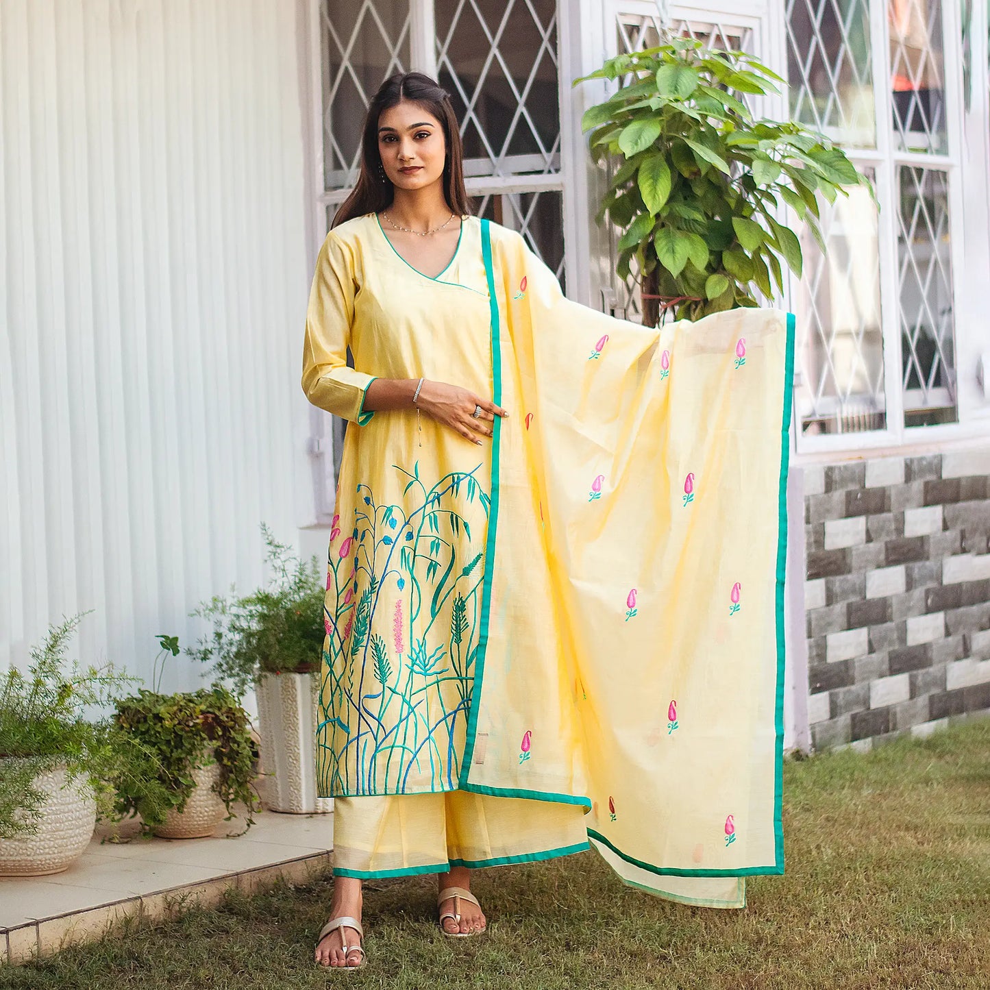 Indian lady posing in a yellow angrakha kurta set with delicate resham embroidery