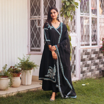 Indian woman wearing a black chanderi angrakha and dupatta with white and blue resham embroidery, paired with matching palazzo.