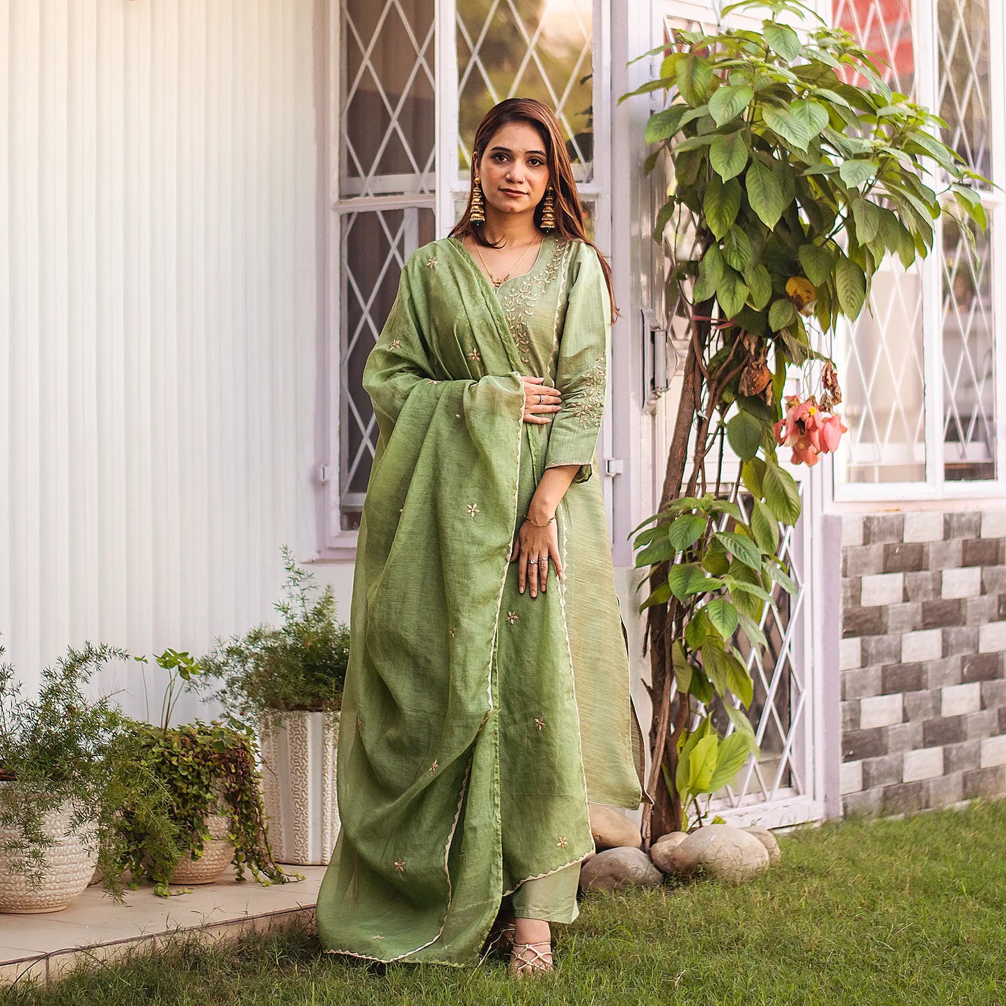 Indian woman wearing a green jute silk kurta and chanderi dupatta with beige applique work, paired with a green palazzo.