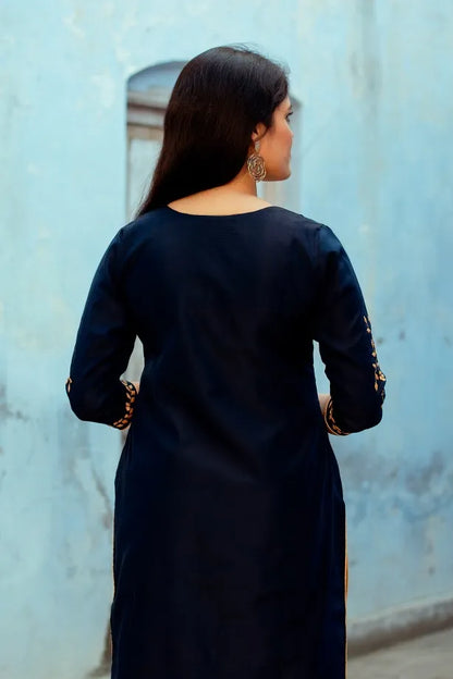 Indian girl poses where the back side of the dark blue chanderi kurta is visible.