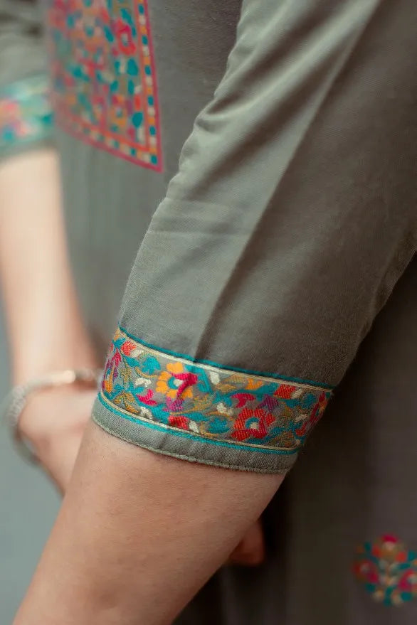 Close-up of hands showcasing the intricate embroidery of a Cotton Kani Suit.