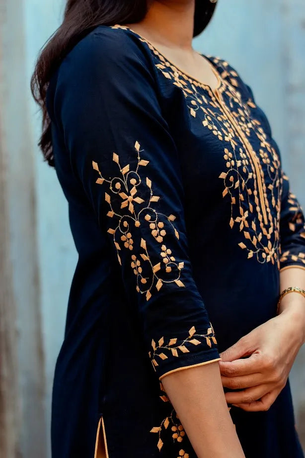 Close up of the sleeve of the dark blue chanderi kurta with golden applique work.