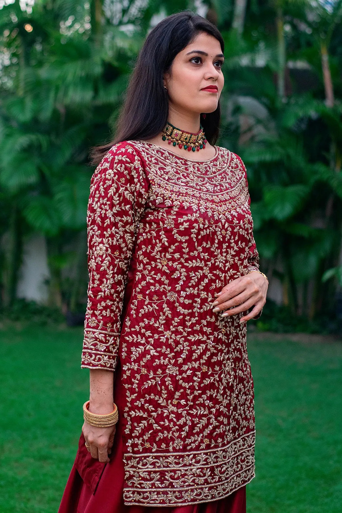 An Indian woman dressed in a stunning hand-embroidered silk Gharara paired with a delicate tissue dupatta.