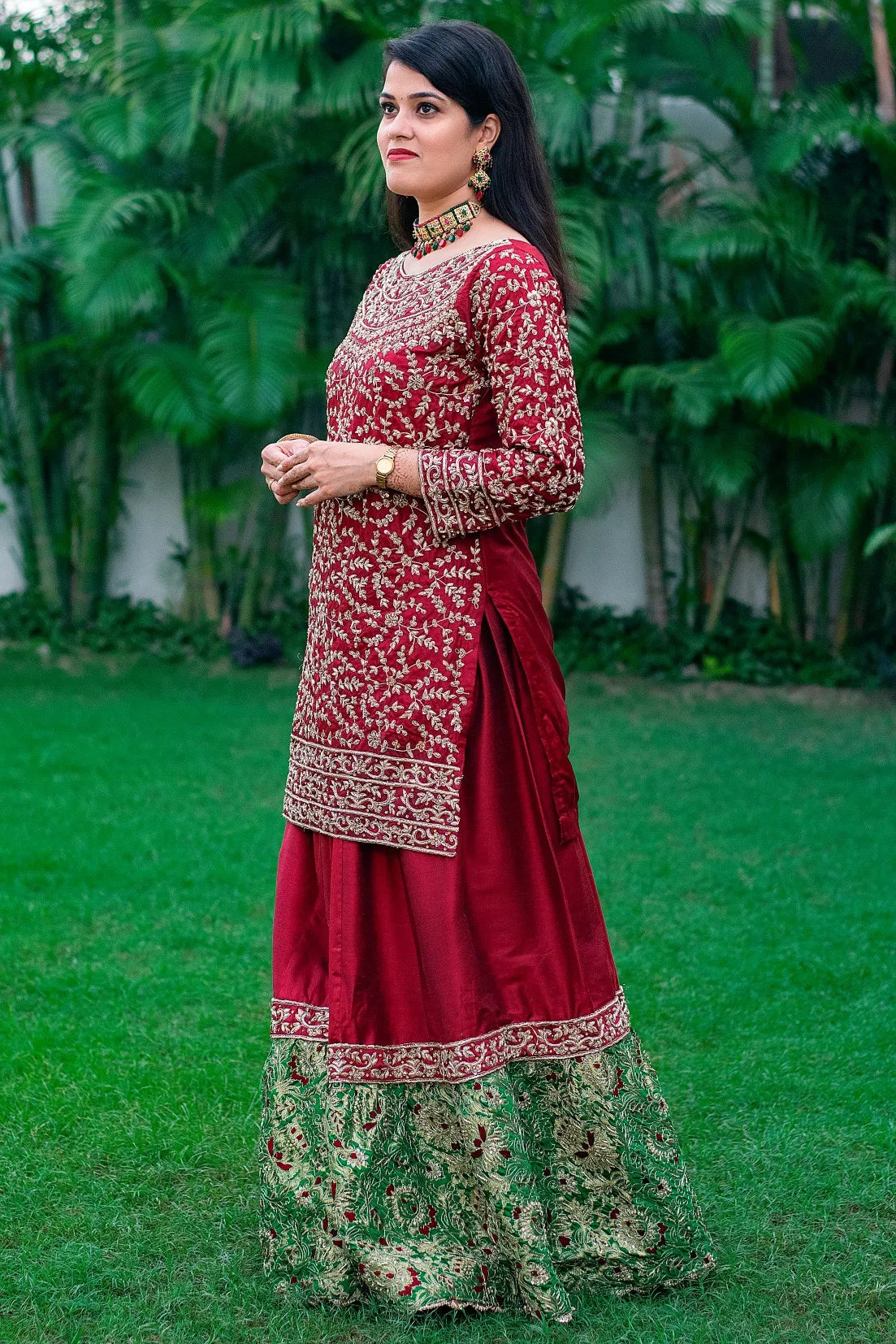 A beautifully adorned Gharara set, featuring intricate hand embroidery on the rich maroon silk fabric.