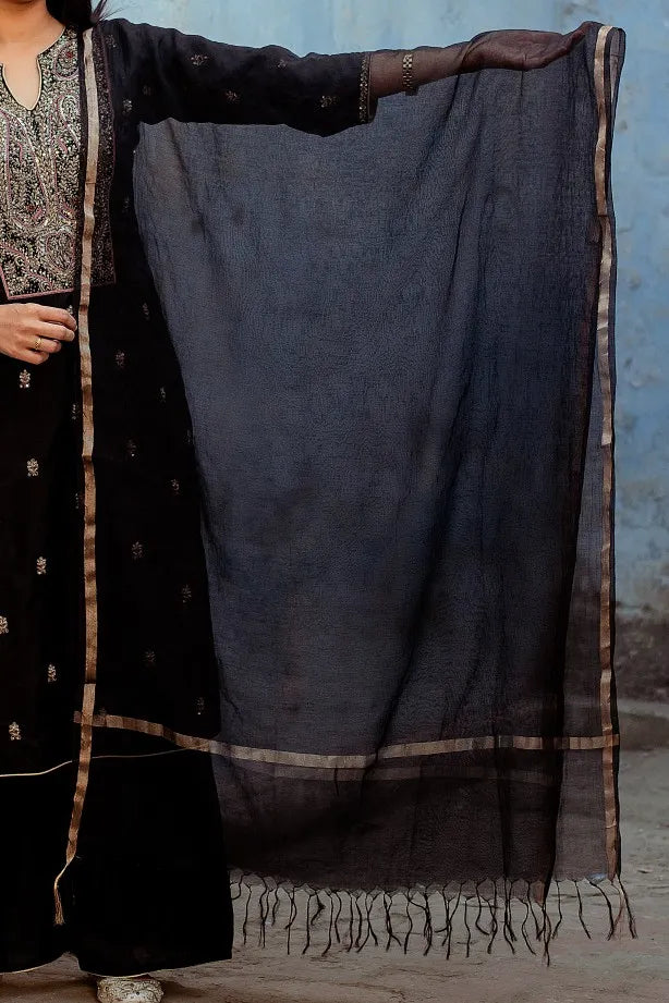 A lady in a black silk kurta with Zardozi embroidery, paired with black palazzo pants and a matching black Chanderi dupatta.
