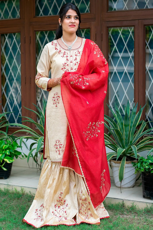 A stunning woman in a shimmering gold Gharara with intricate applique work.