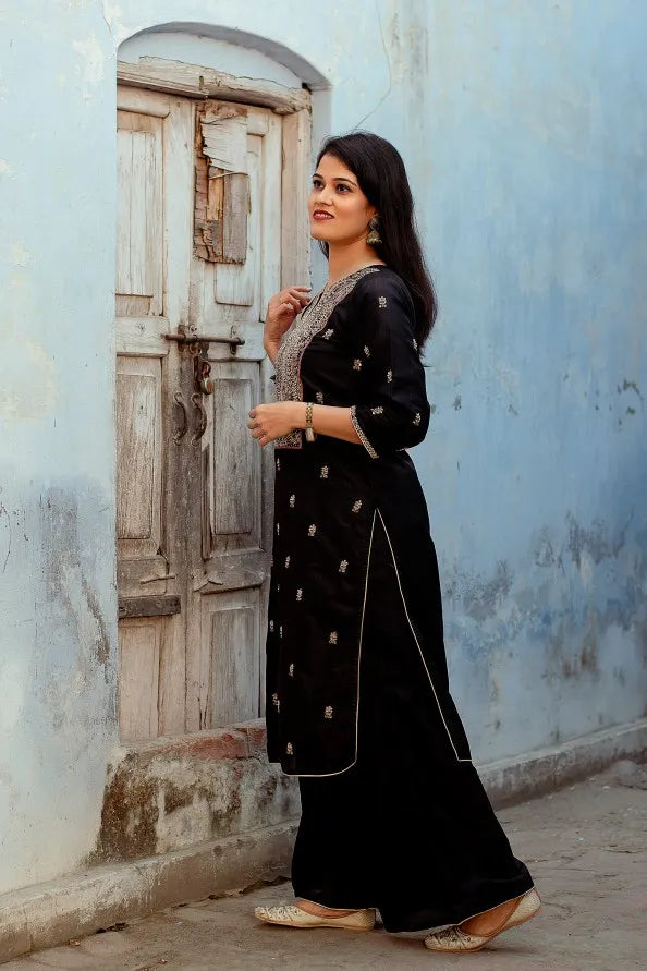 A stunning lady in a black silk kurta with Zardozi embroidery, a matching black Chanderi dupatta, and palazzo pants.