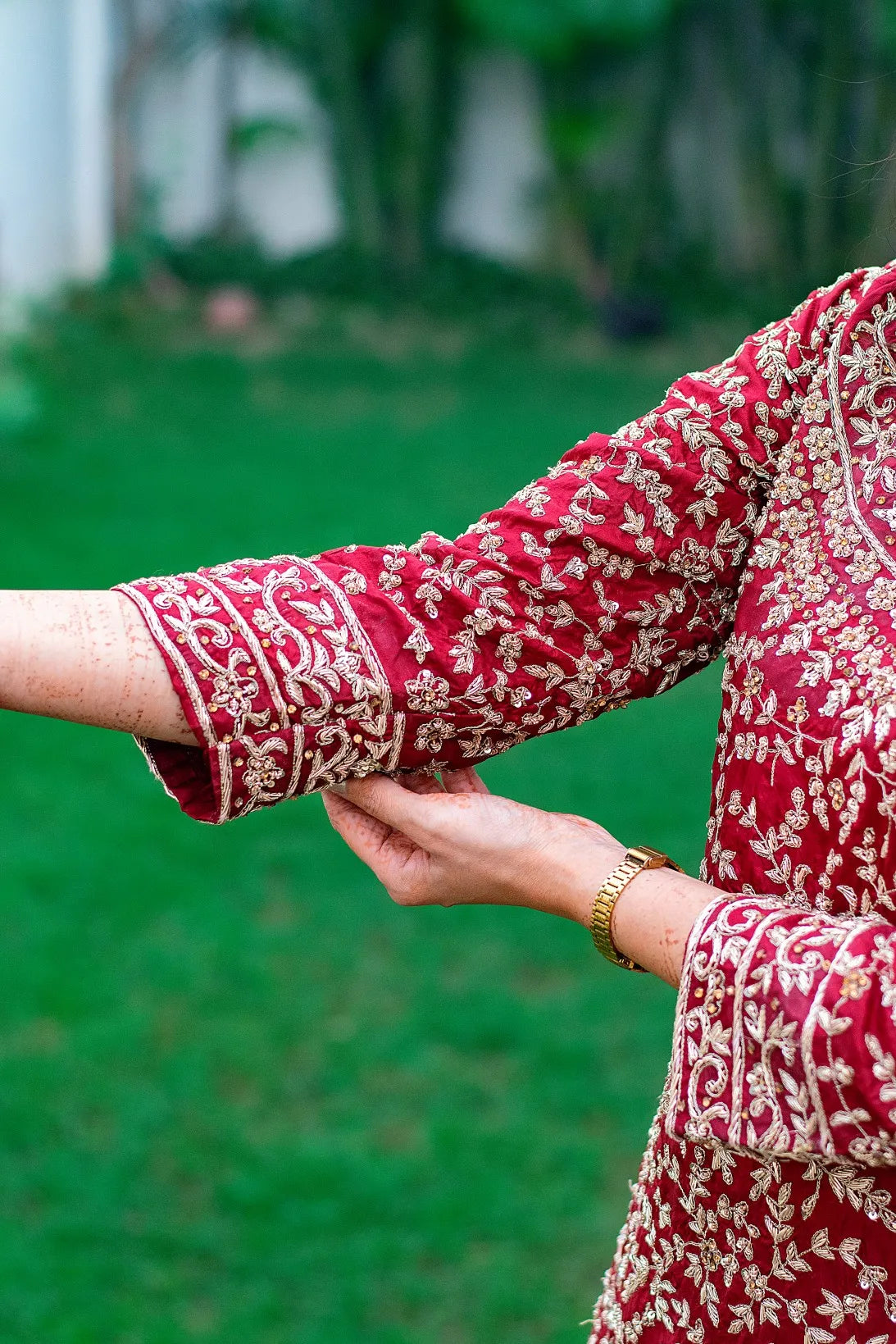 A woman showcasing her elegant style in a hand-embroidered maroon silk Gharara and tissue dupatta.