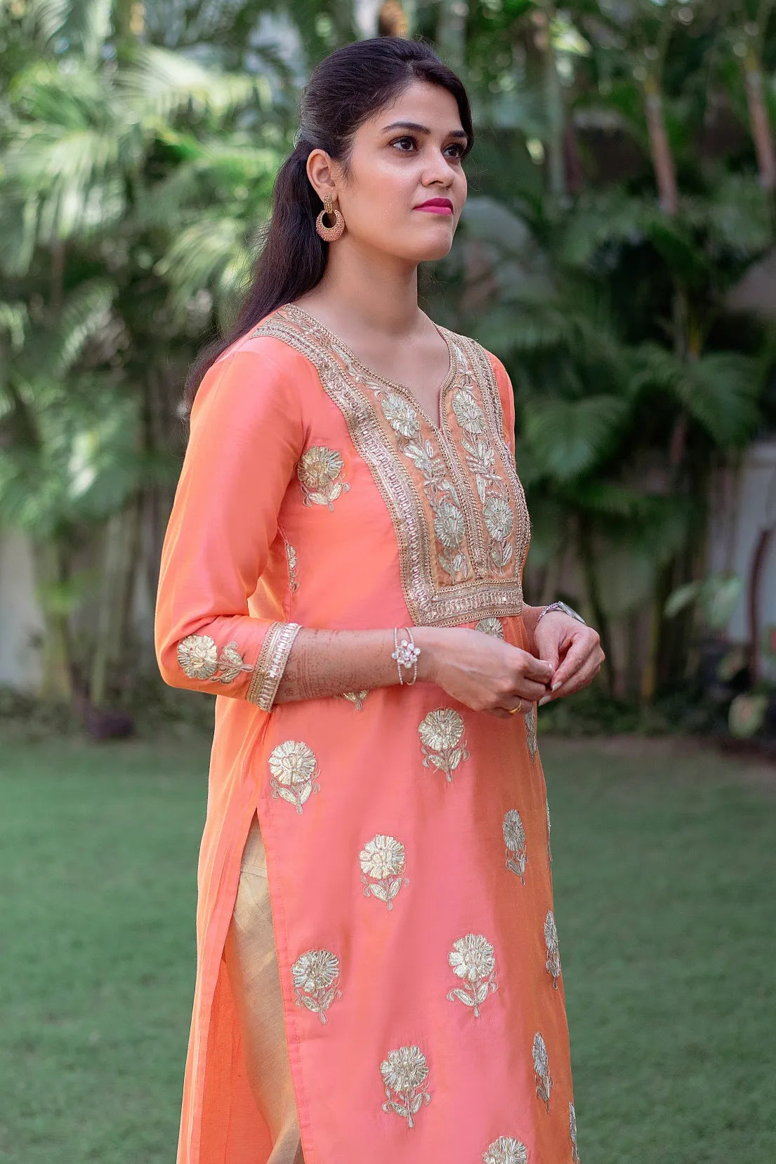 Vibrant Peach Chanderi Kurta and Dupatta with exquisite Gota Work, styled with a Golden Churidar.