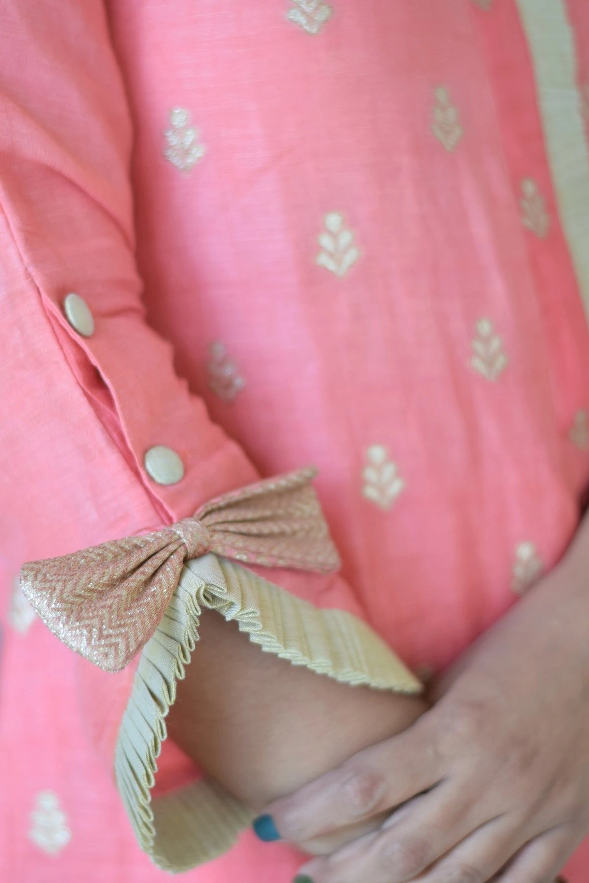 A peach-colored linen kurta with a straight cut and side slits on a woman.
