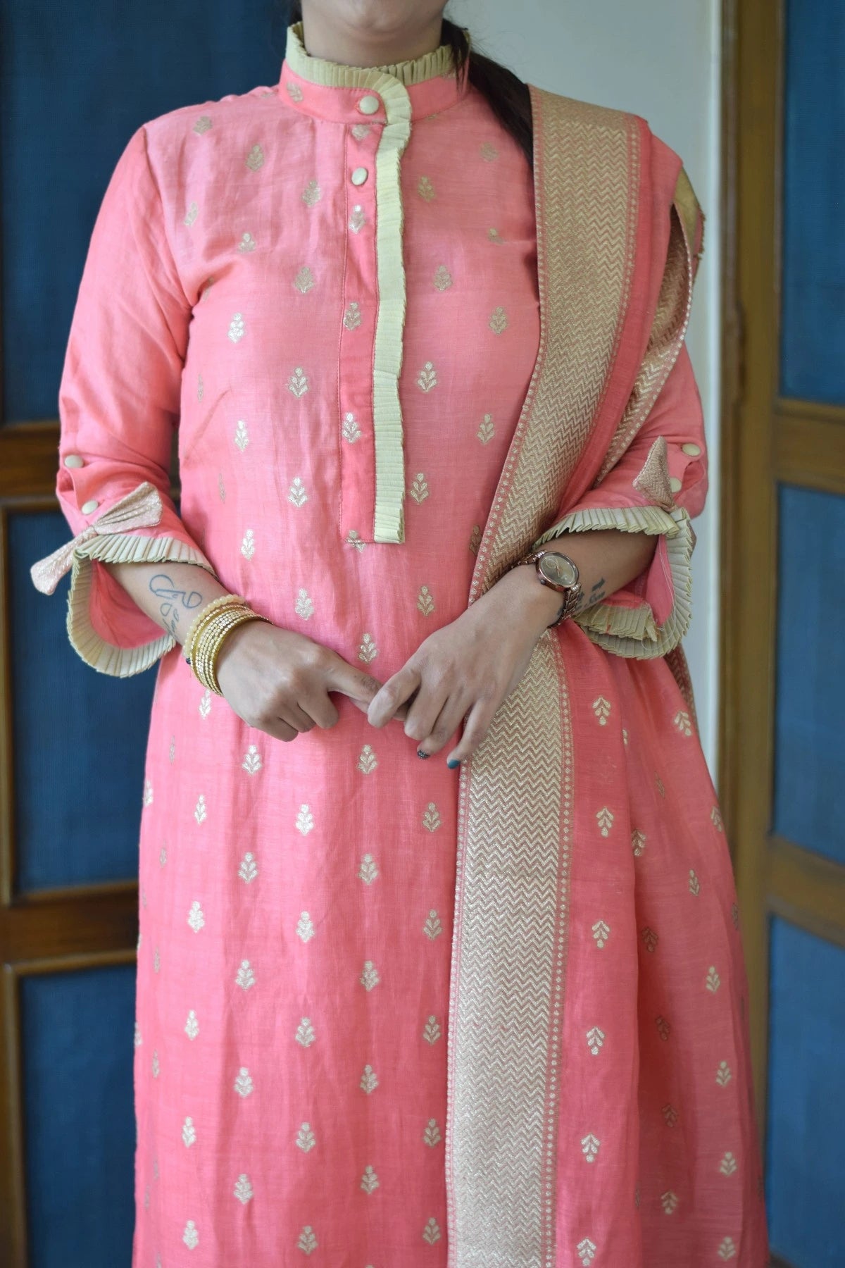 An Indian woman wearing a peach linen kurta with long sleeves.