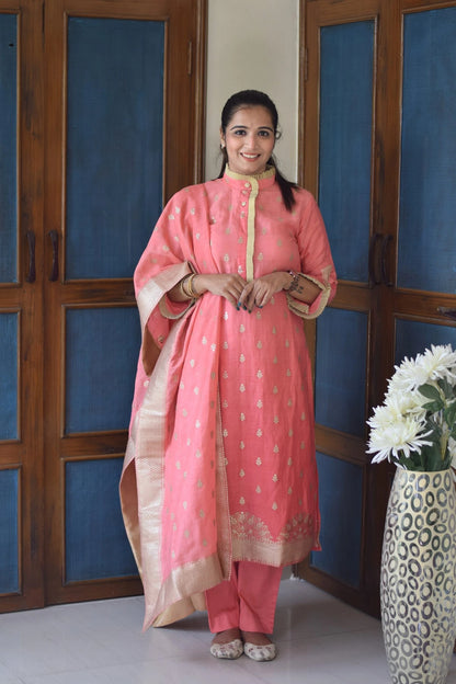 A close-up of a woman's peach linen kurta with golden floral designs.