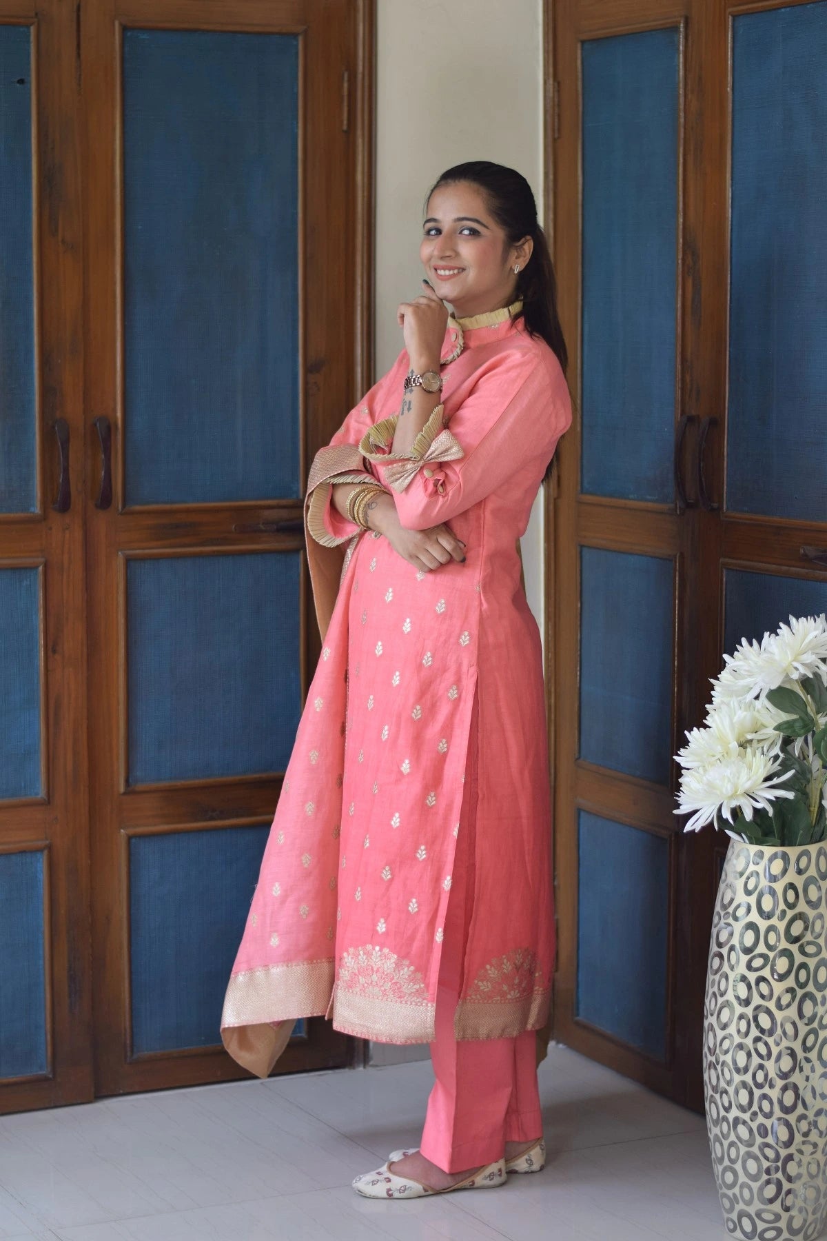 A peach-colored linen kurta with silver threadwork worn by an elegant Indian woman.