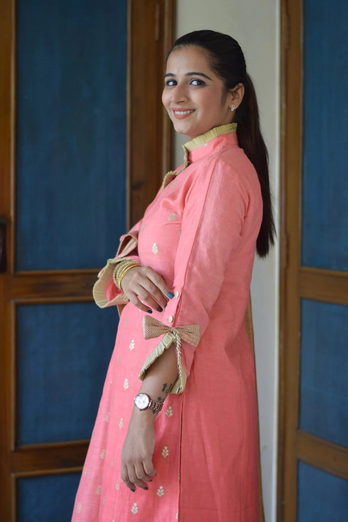 A woman in a peach linen kurta with minimal embroidery and a straight neckline.