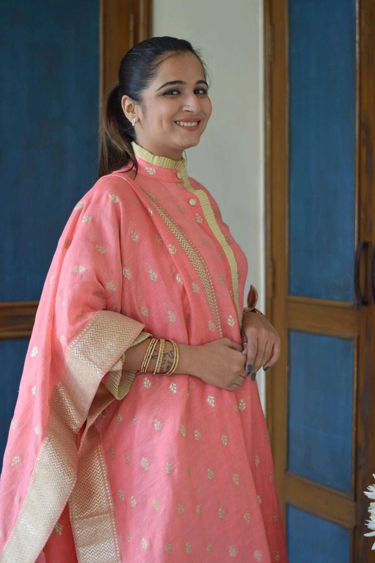 A peach-colored linen kurta with a high-low hemline and mandarin collar on a woman.