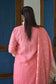 A woman in a flowy peach linen kurta with a simple round neckline.