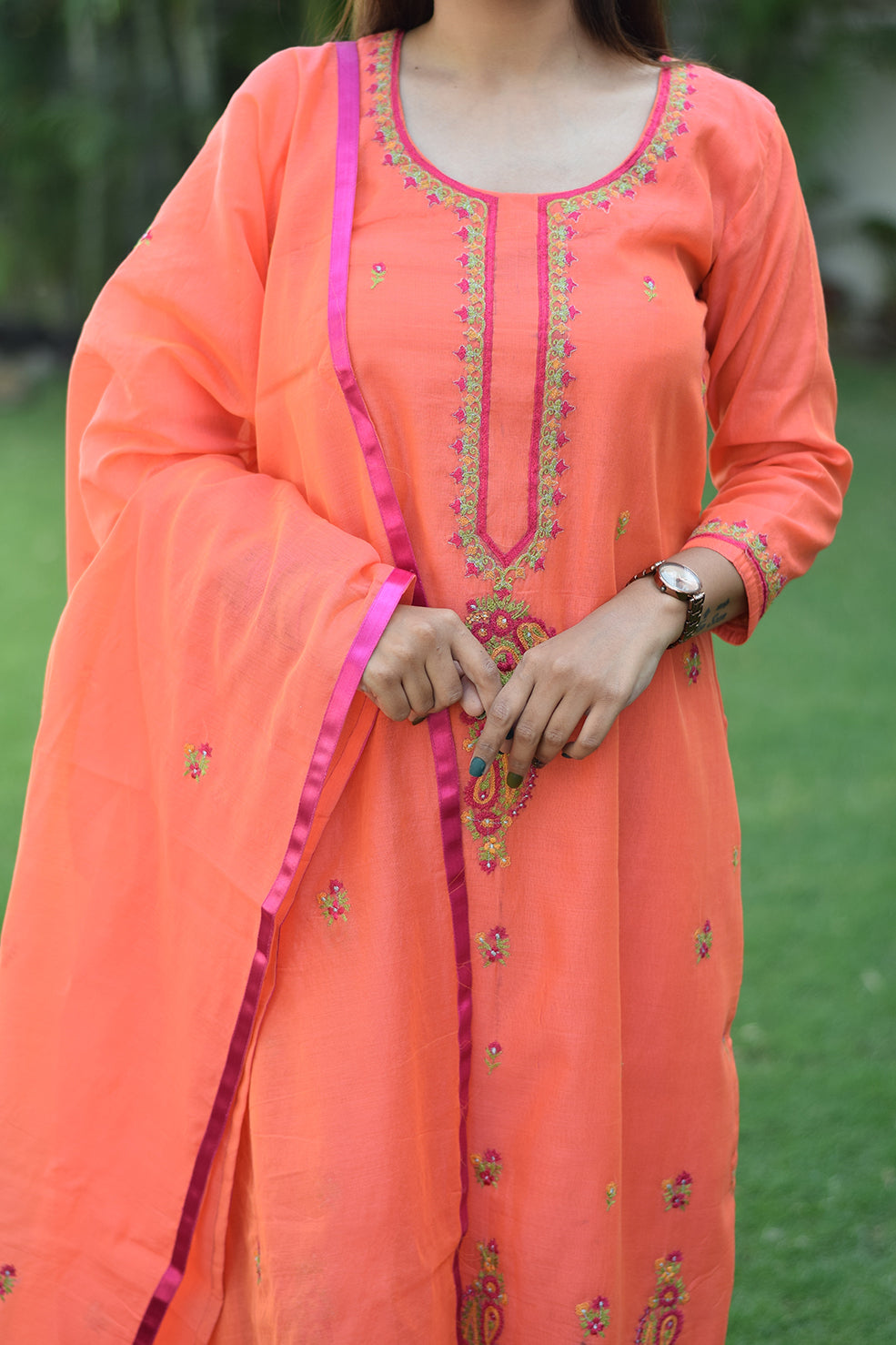 A woman wearing a peach chanderi embroidered kurta and matching dupatta, paired with peach trousers.