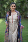 A solo woman wears a beige kurta with a blue silk jamawar dupatta set.