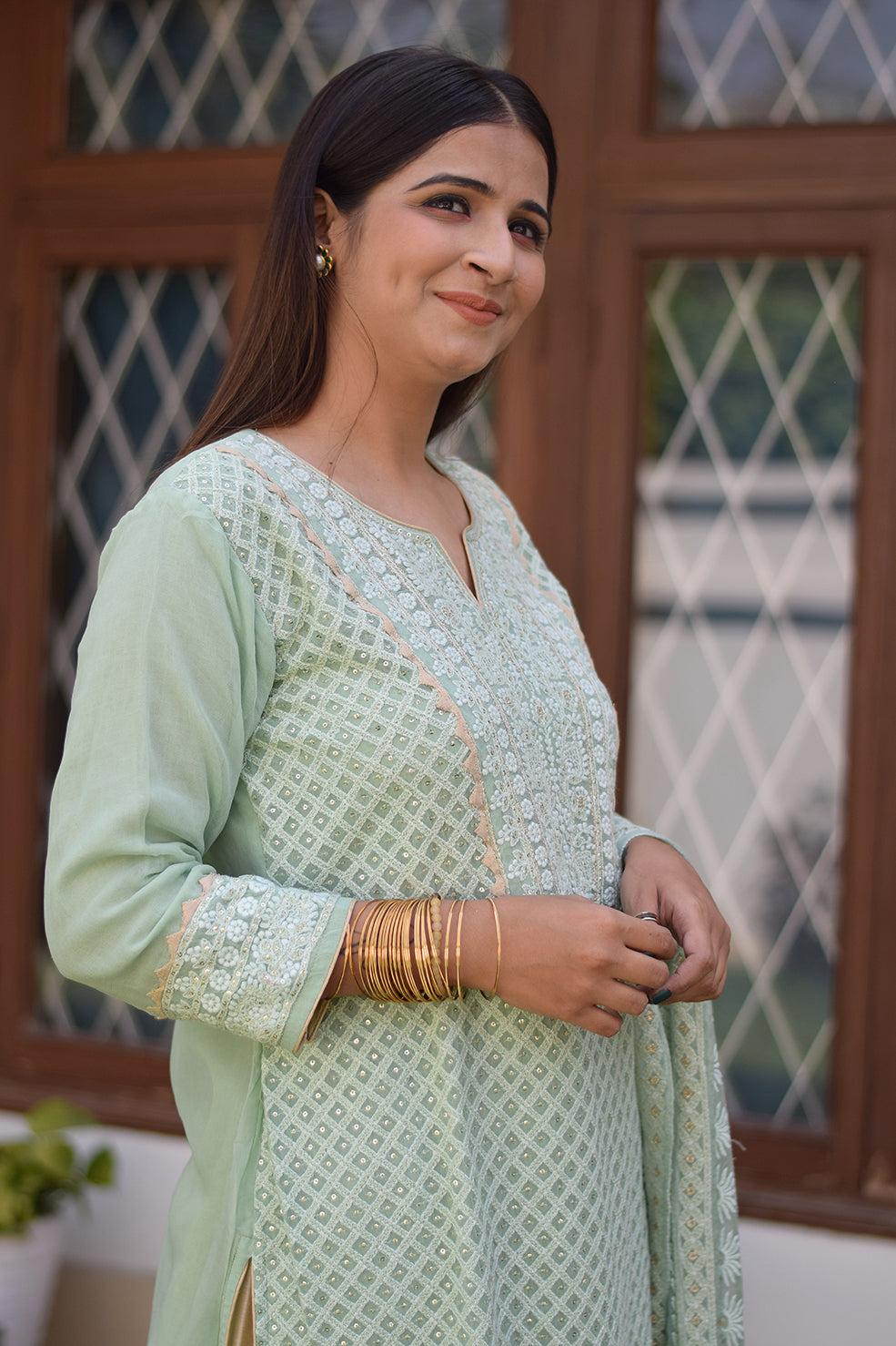 A solo female dressed in an exquisite green chikankari kurta set, highlighting traditional Indian fashion.