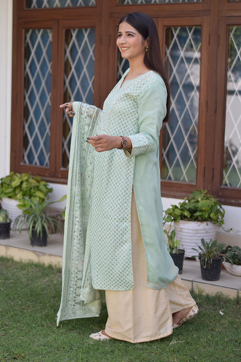 A fashionable Indian woman donning a green chikankari kurta set.