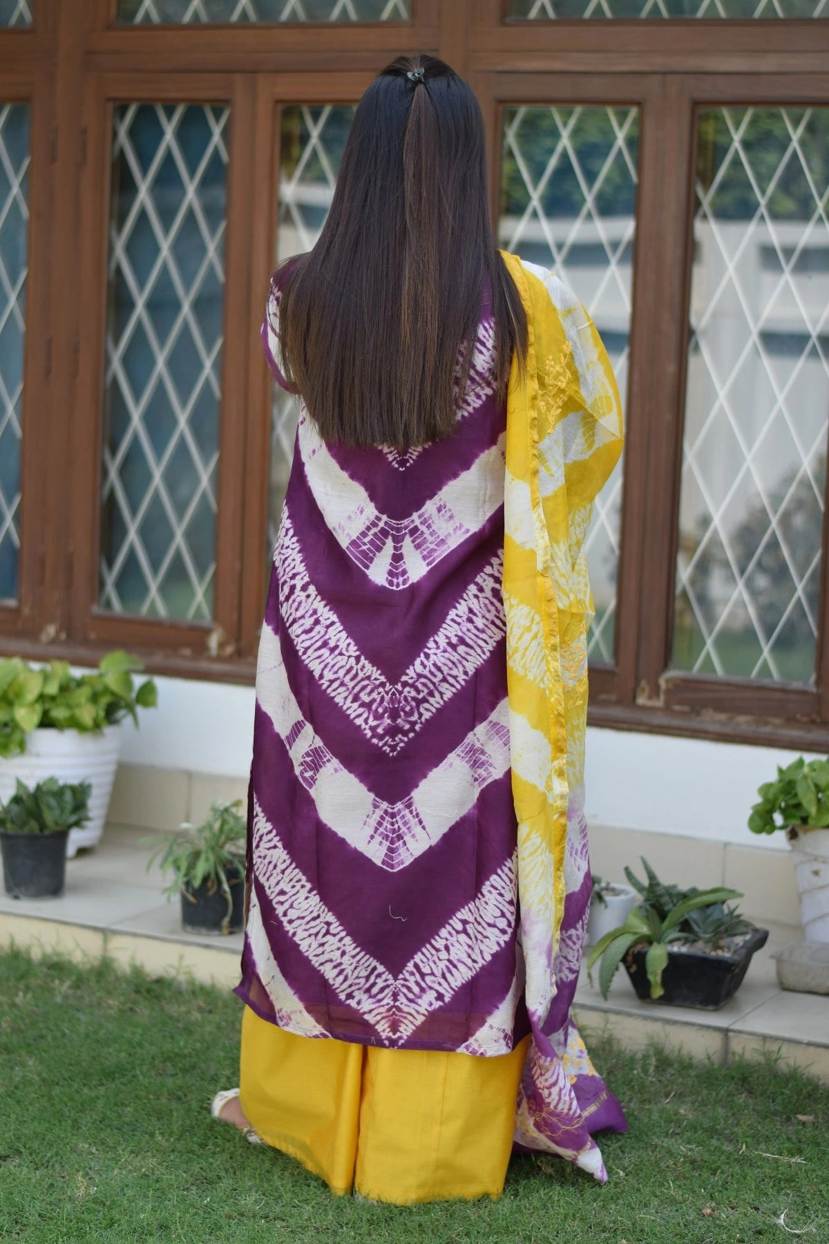 An Indian outfit featuring a beautiful maheshwari kurta and dupatta in shades of purple and yellow, paAn Indian outfit featuring a beautiful maheshwari kurta and dupatta in shades of purple and yellow, paired with flowy yellow palazzo pants.ired with flowy yellow palazzo pants.