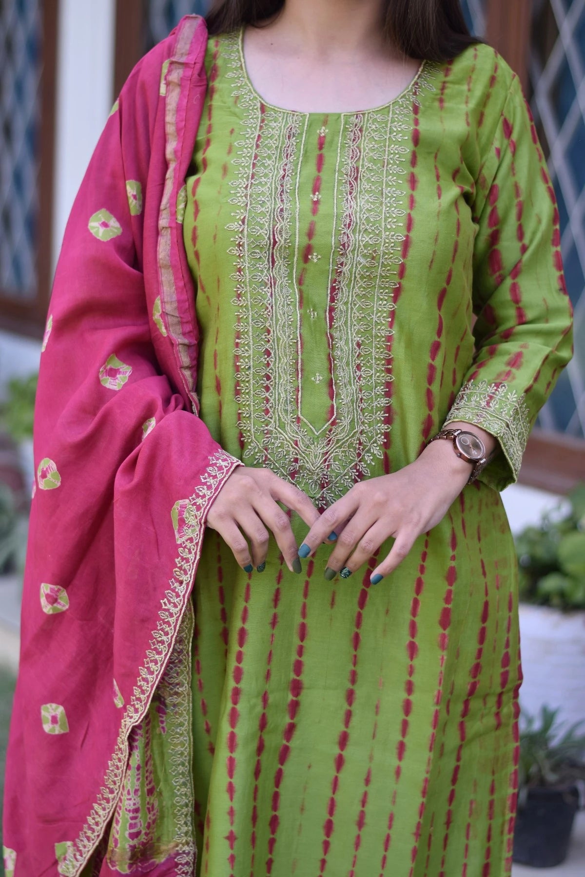 A stunning lady wearing a zari hand work suit with intricate patterns that showcase the rich cultural heritage of India.