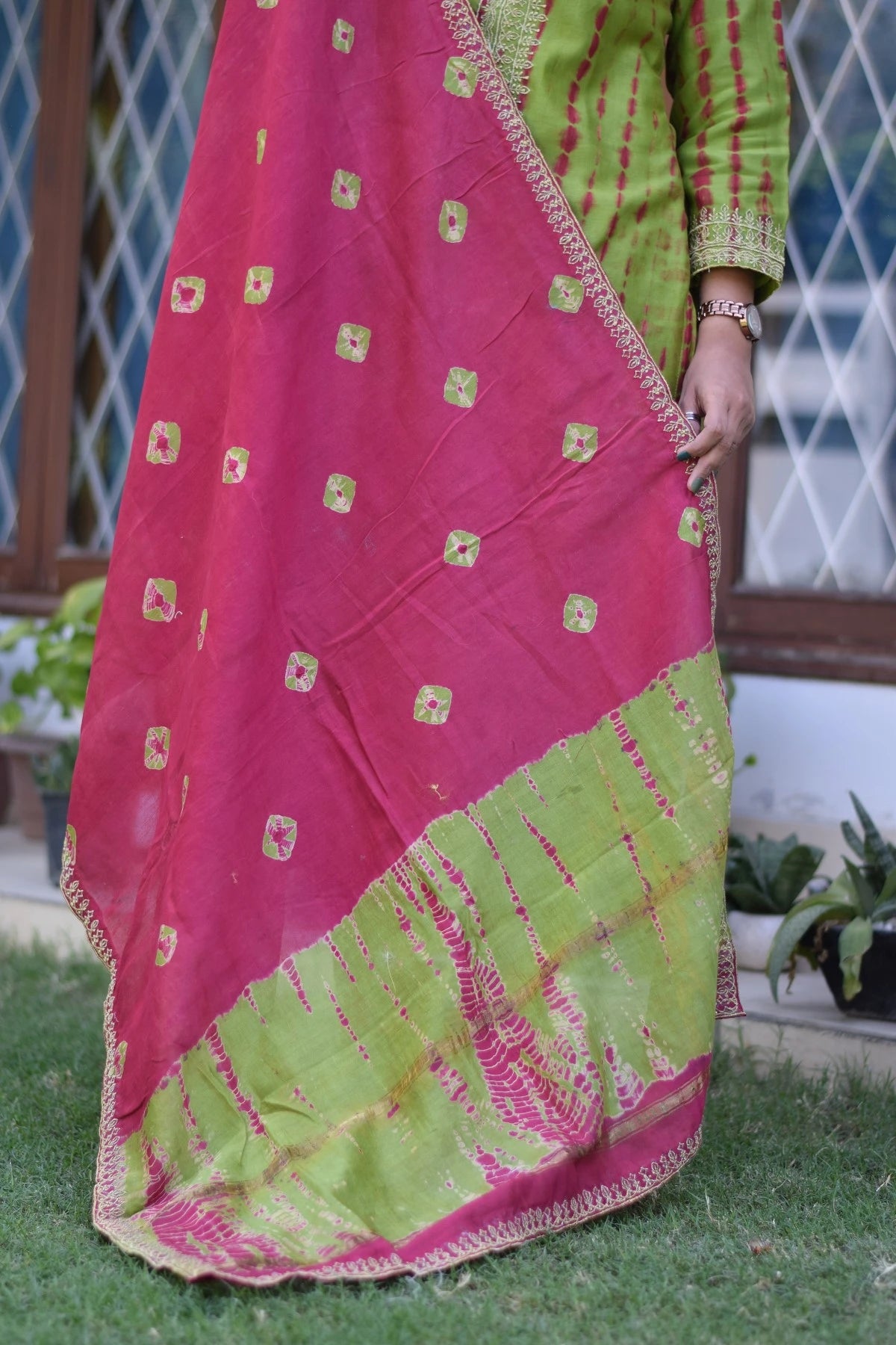 An elegant woman wearing a traditional zari hand work suit with intricate floral designs.