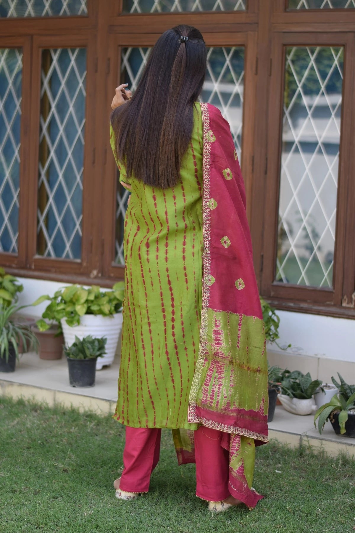 A graceful lady wearing a zari hand work suit, showcasing the artistry of skilled craftsmen.