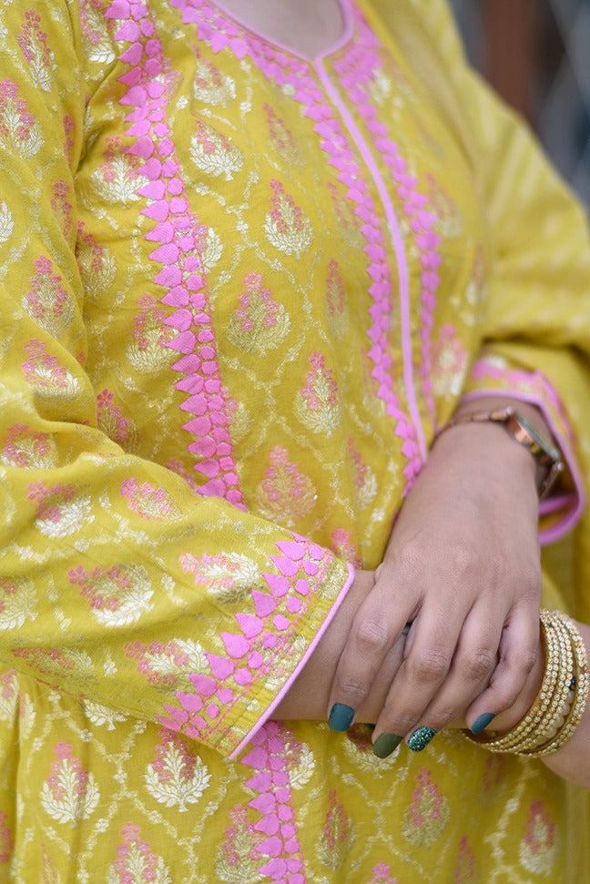A woman showcasing her impeccable taste in fashion by wearing a yellow Banarasi cotton silk kurta.