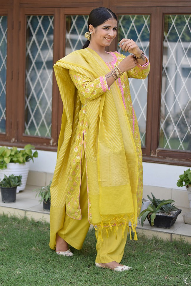 A young lady wearing a beautiful yellow Banarasi cotton silk kurta with gold accents.