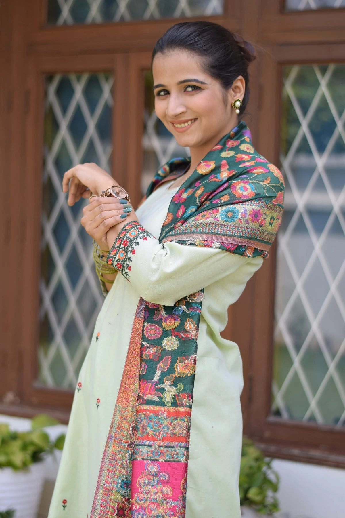A woman looking gorgeous in a green silk jamawar dupatta with a green chanderi resham embroidered kurta and palazzo.