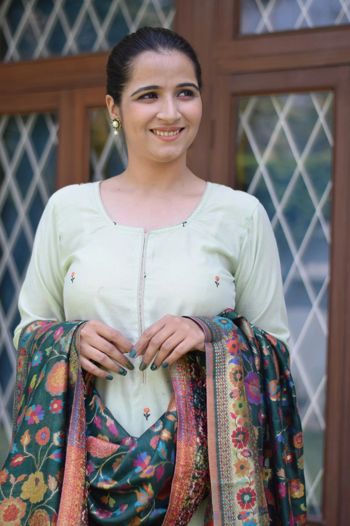 A beautiful green outfit with a silk jamawar dupatta, chanderi resham embroidered kurta, and palazzo worn by a woman.