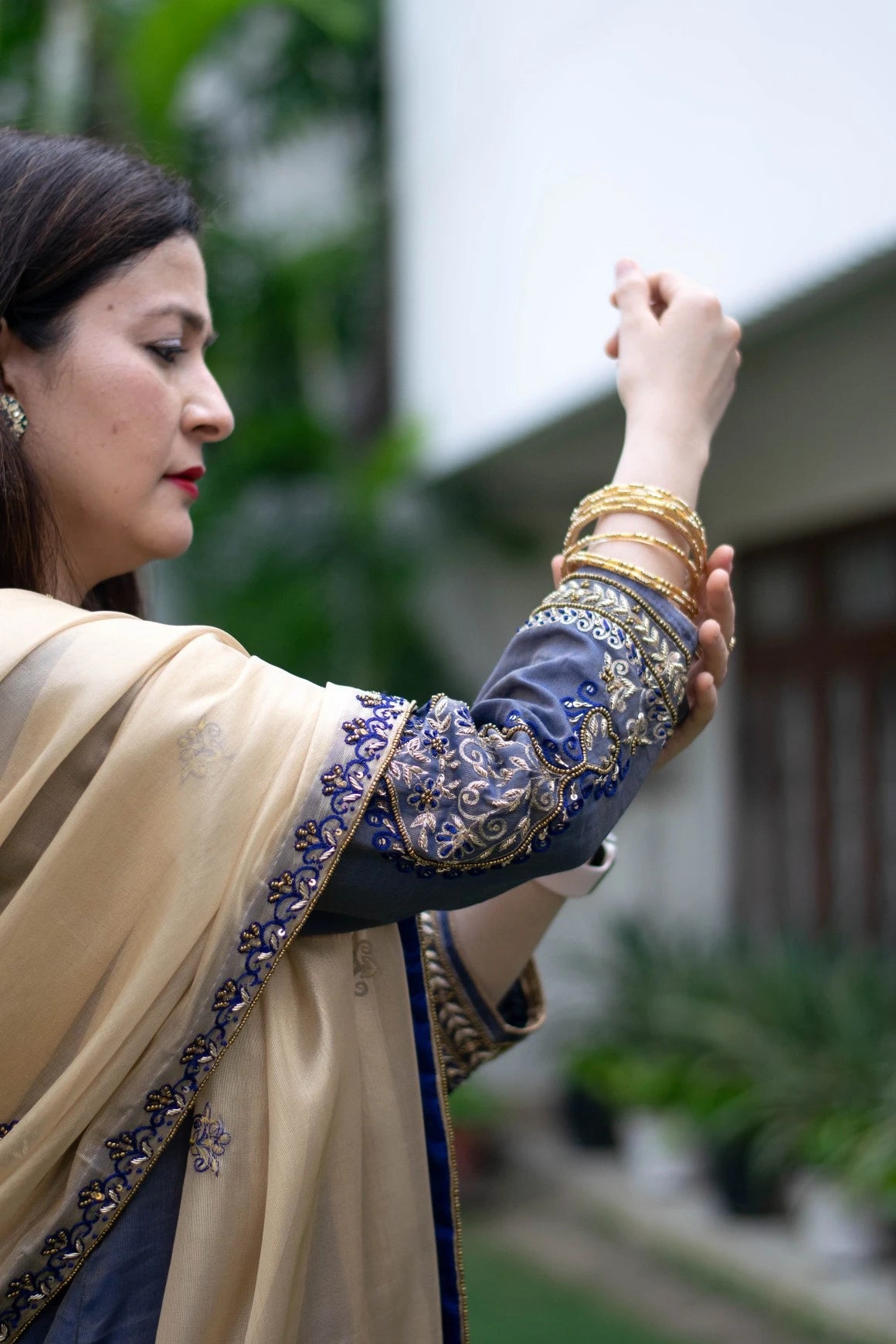 An elegant blue kurta with gold embroidery paired with a stunning gold tissue dupatta and palazzo pants, worn by a stylish woman.