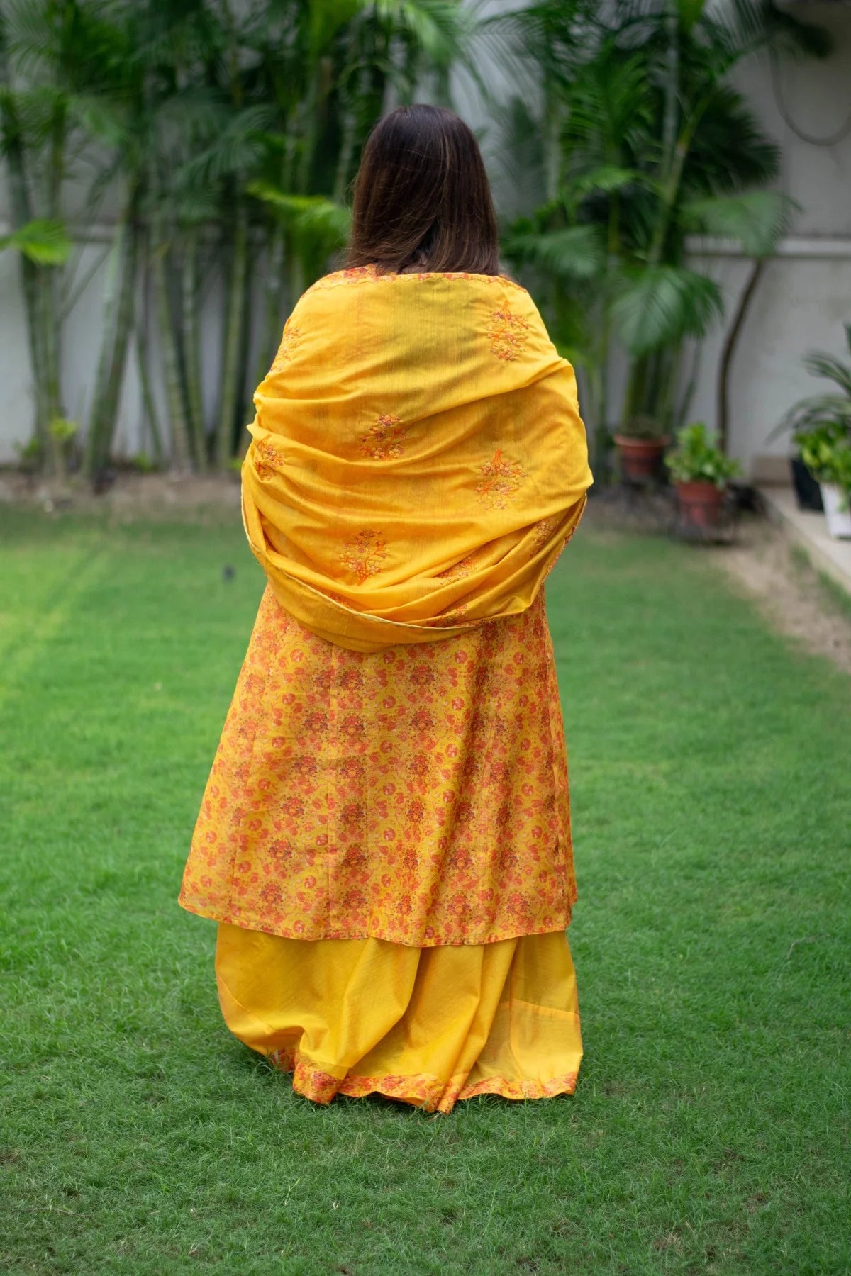 A woman radiates joy in a sunny yellow Chanderi Kurta with silver accents.