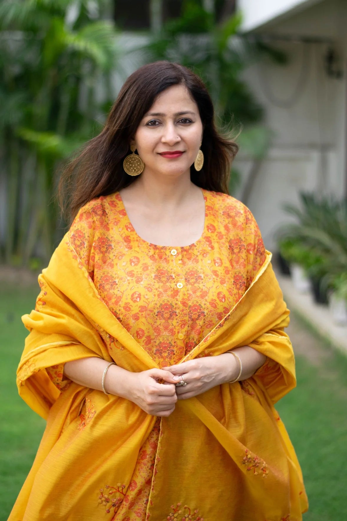 A beautiful woman in a yellow Chanderi Kurta smiles at the camera.